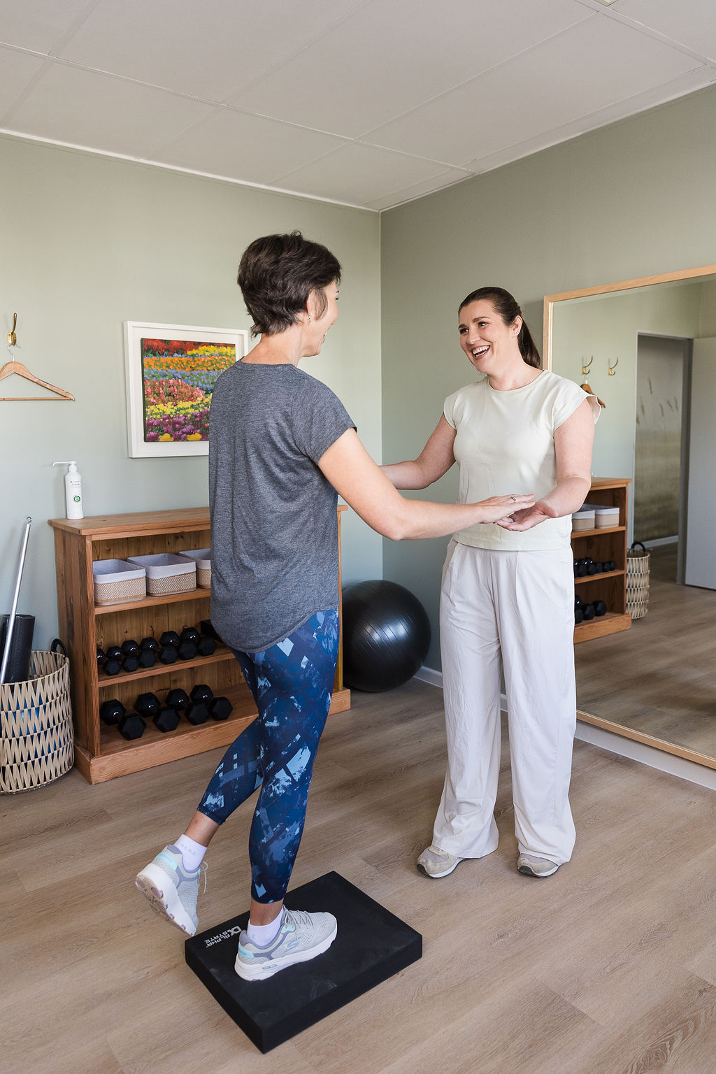Melissa McLaren supervising a balance exercise on a wobble board
